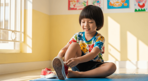 Bé trai Việt Nam tự đi giày dép vui vẻ trong phòng sáng